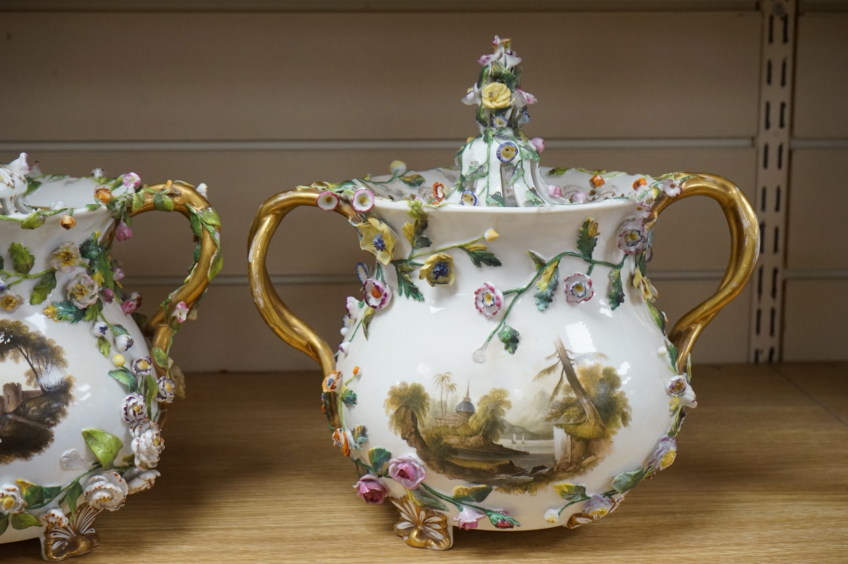 A pair of Rockingham two handled pot pourri vases and covers, c.1830-42, the first painted with two named views near Lyme, Dorsetshire and Stockly Bridge’, The second with an unnamed view of a monument by a lake, the rev